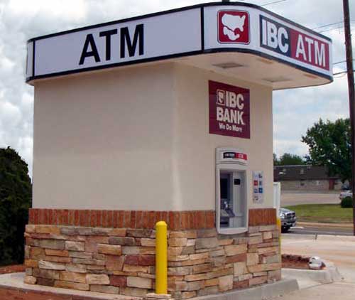Photo of an ATM installed as a standalone kiosk with stucco walls