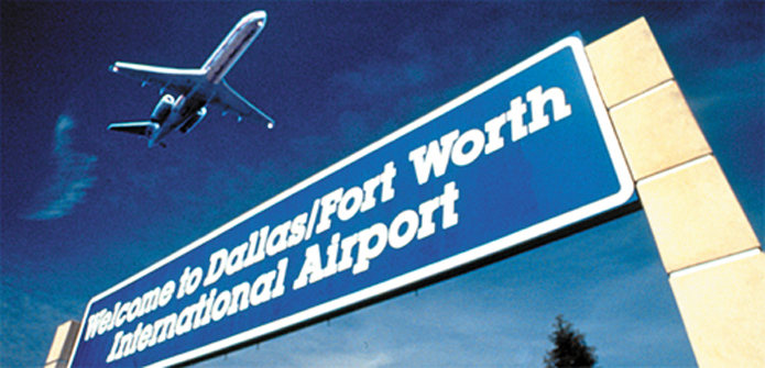 Picture of Dallas / Ft. Worth airport sign with airplane in background, nearby Dallas Warehouse